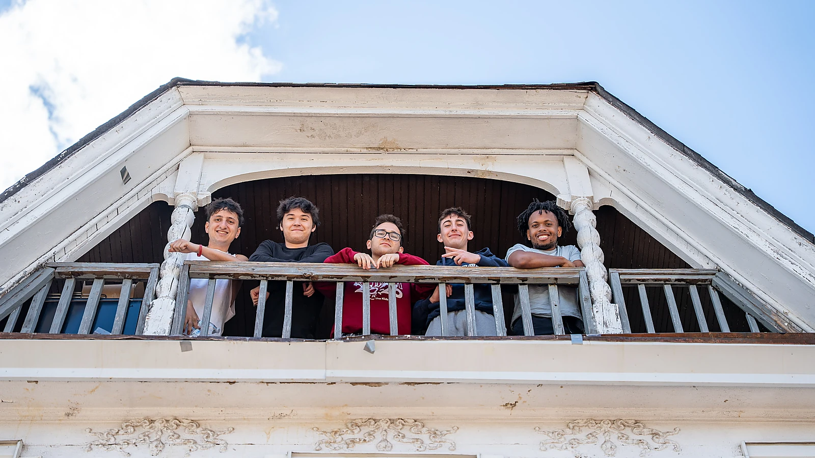 Beta Delta brothers standing on a balcony