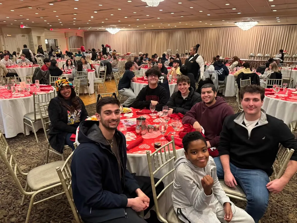 Beta Delta brothers seated with Myles at an RU4Kids Foundation event